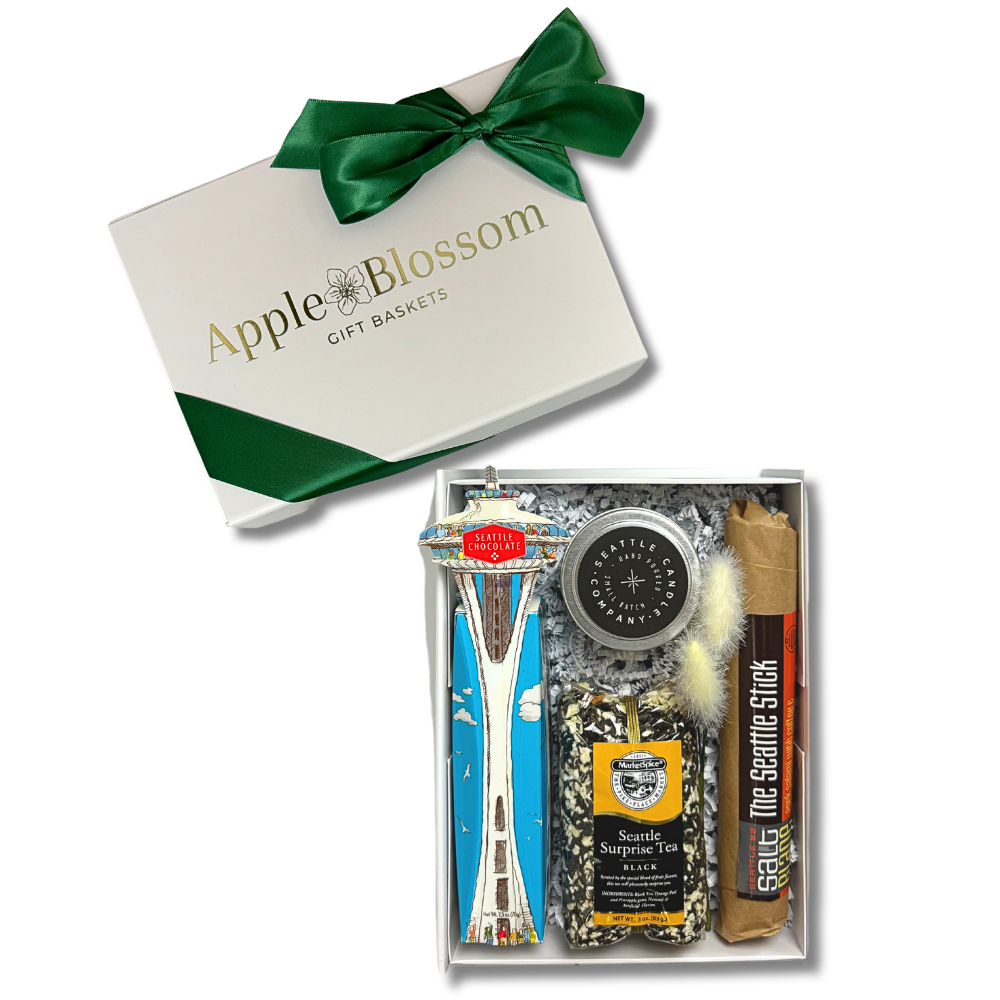 the seattle gift box features a space needle truffle gift box, seattle sprprise loose tea, seattle candle company coffee candle and the seattle stick salami.  The gift come is a white soft touch gift box with a green ribbon