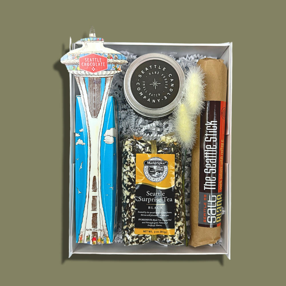 the seattle gift box features a space needle truffle gift box, seattle sprprise loose tea, seattle candle company coffee candle and the seattle stick salami