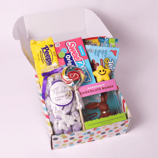 Festive Easter gift box filled with sweet treats, including a Hammond's chocolate bunny, Peeps marshmallow chicks, SweetTarts, Teddy Grahams, saltwater taffy, and colorful lollipops—perfect for celebrating spring.