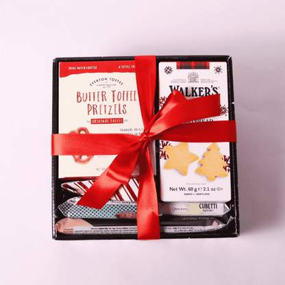 Corporate holiday gift tray featuring locally sourced snacks, presented in a holiday-themed tray with a festive bow.