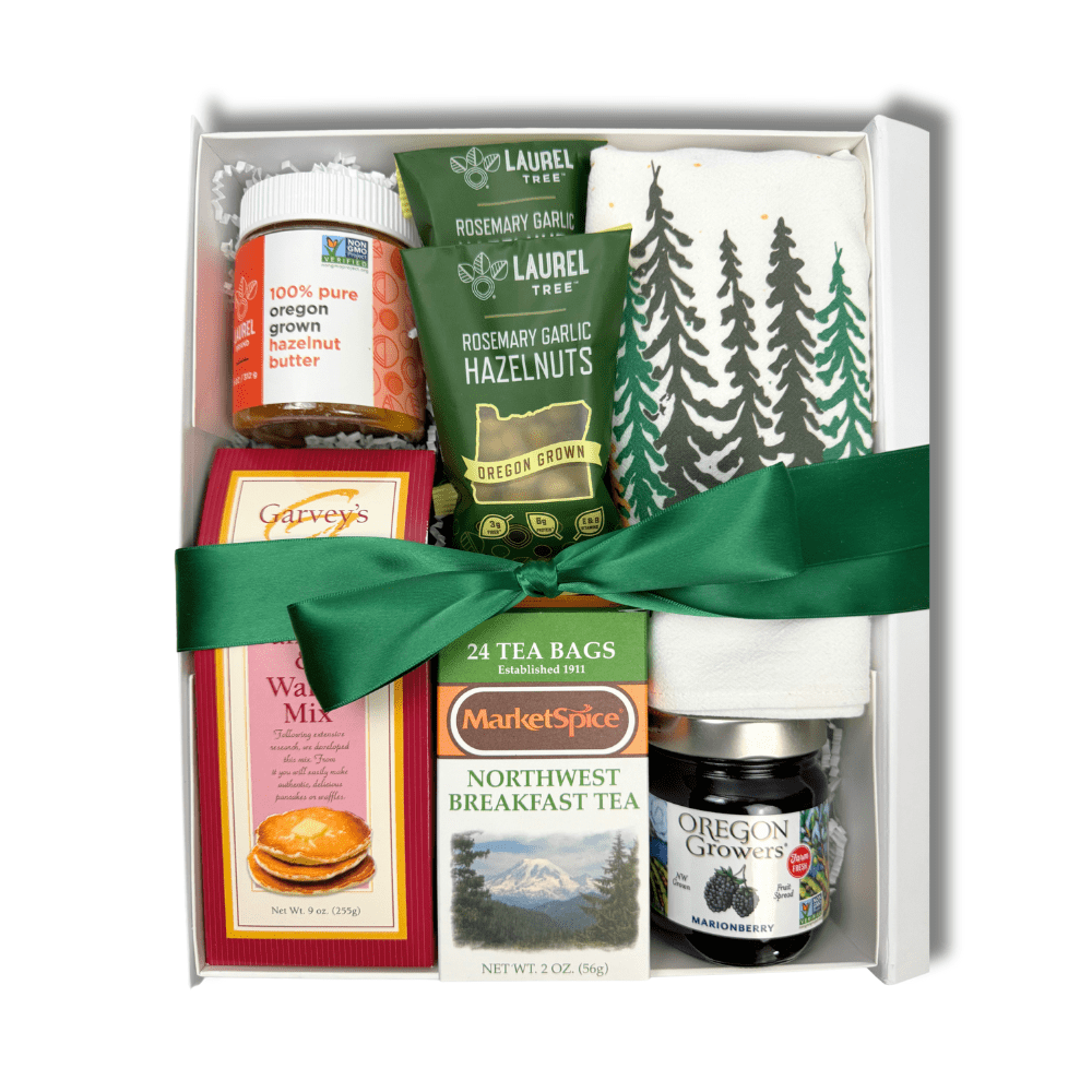 Pacific Northwest Breakfast gift box is the perfect housewarming, employee onboarding or thank you gift.  It is loaded with products made in WA and OR and includes organic pancake mix, hazelnut butter, roasted hazelnuts, woodsy kitchen towel, marionberry jam, northwest breakfast tea all in a luxury white gift box with a green satin bow.