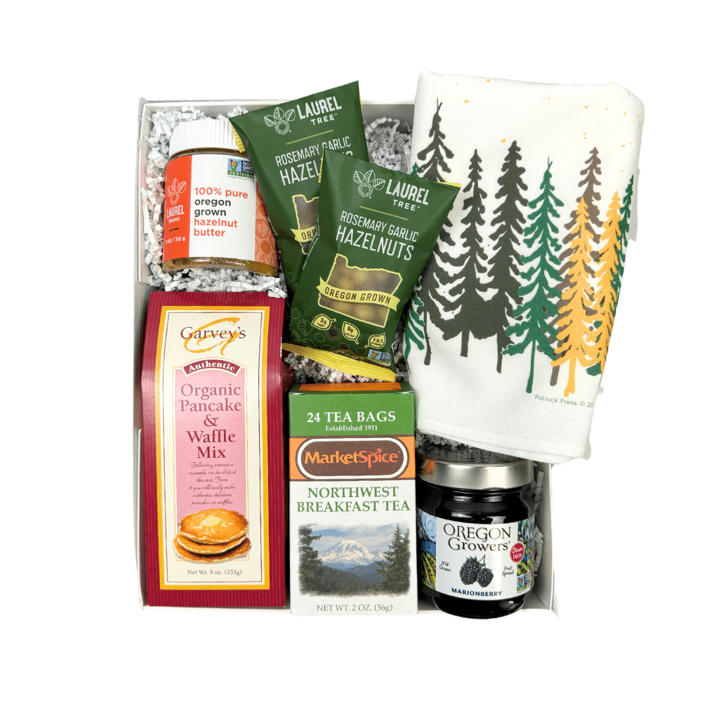 Pacific Northwest Breakfast gift box is the perfect housewarming, employee onboarding or thank you gift.  It is loaded with products made in WA and OR and includes organic pancake mix, hazelnut butter, roasted hazelnuts, woodsy kitchen towel, marionberry jam, northwest breakfast tea all in a luxury white gift box with a green satin bow.