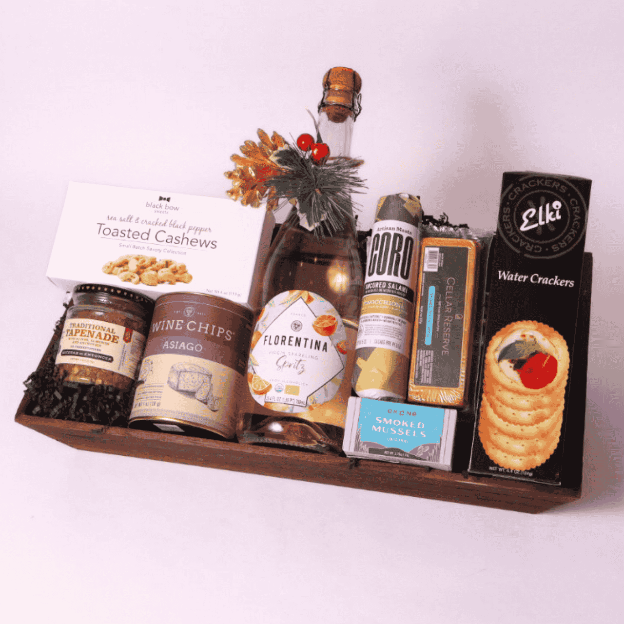 Pacific Northwest luxury gift basket on a reusable wooden tray, featuring gourmet local snacks like Asiago wine chips, smoked cheese, uncured salami, and tapenade.