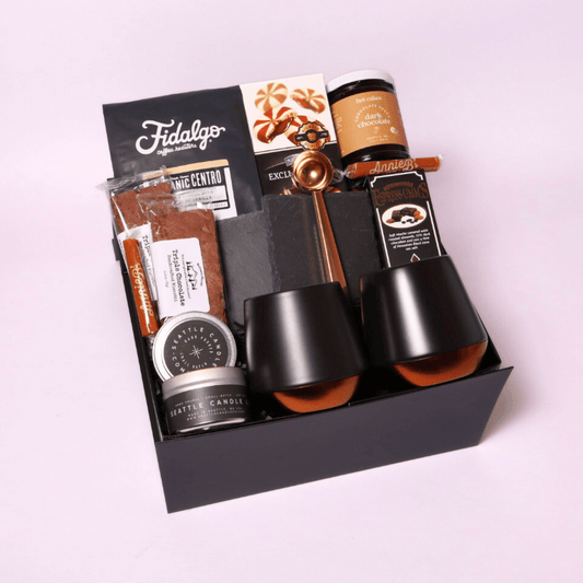 The Regal Coffee gift box in black signature packaging, filled with premium coffee essentials including double-walled ceramic mugs, Fidalgo organic coffee, and gourmet treats.