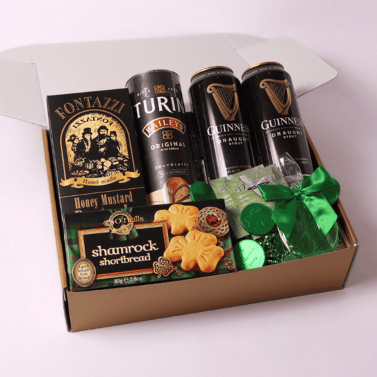 St. Patrick’s Day gift box featuring Guinness beer, Bailey’s chocolates, shamrock cookies, Irish tea, and festive chocolates, beautifully arranged in a gold box.