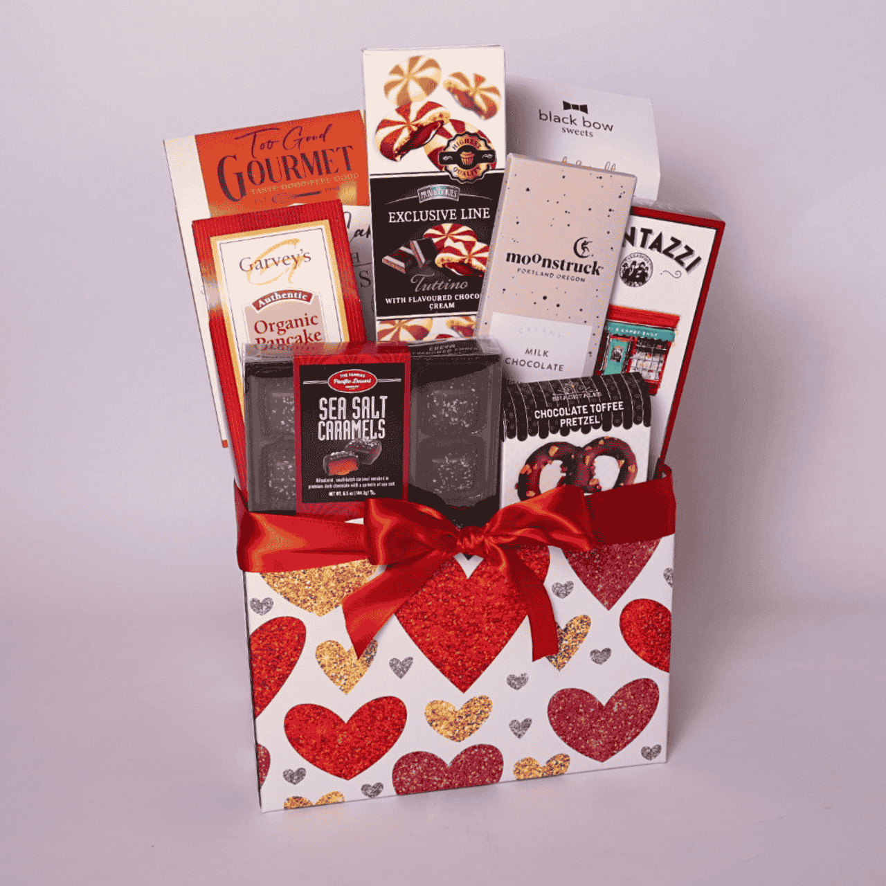 Valentine's gift box filled with gourmet snacks, including chocolate brownie cookies, yogurt pretzels, and artisan milk chocolate. A perfect college care package or snack box for her, this gift basket is ideal for spreading love on Valentine's Day.