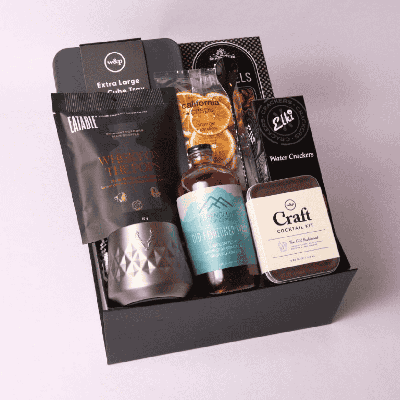 Luxury whiskey-themed gift box filled with premium items: stainless whiskey tumbler, craft cocktail kit, whiskey popcorn, ice cube mold, and more—perfect for bourbon enthusiasts.