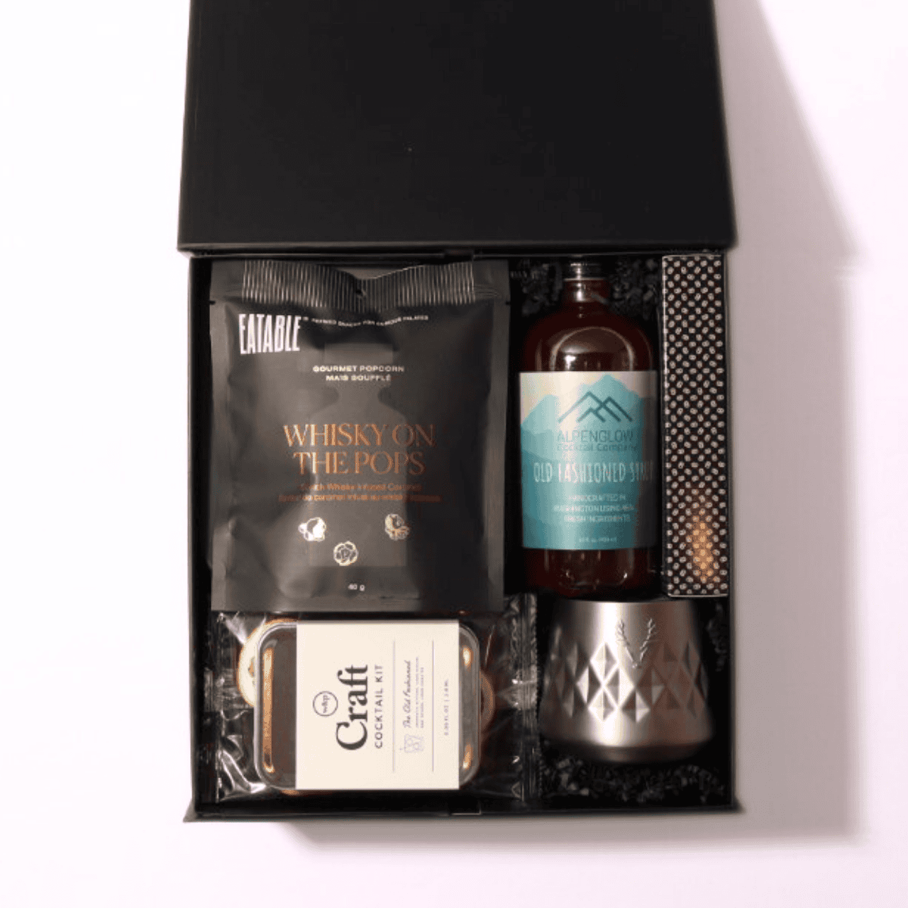 Whiskey and bourbon gift set with a luxury black box, hand-tied bow, and essentials like a cocktail kit, whiskey popcorn, ice cube mold, and optional recipe book.